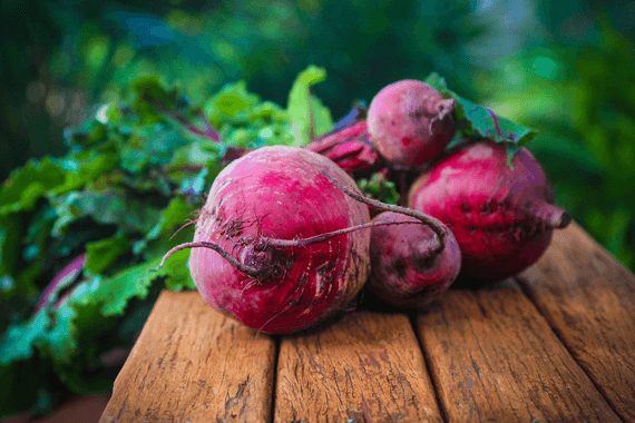 5 ripe beets on cutting board.