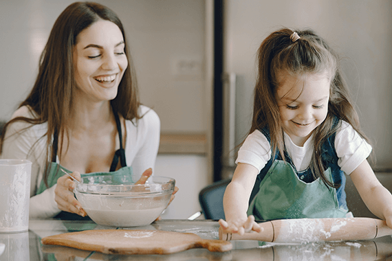 Mother and daughter in kitchen baking vegan cookies.