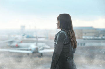 Woman with travel anxiety staring at airplane.