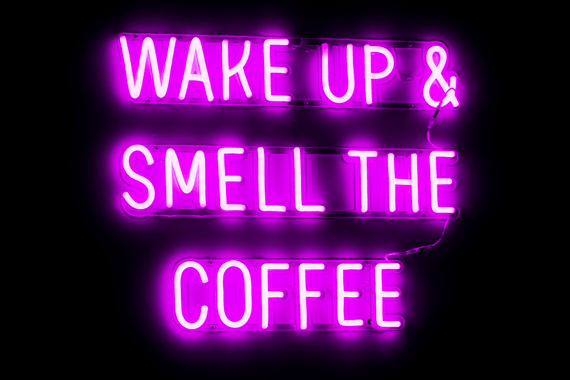 Pink neon sign at coffee house that reads "Wake Up & Smell the Coffee"