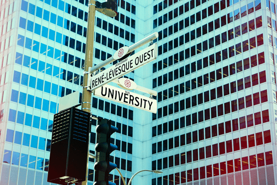 University street sign with skyscraper in background, downtown Montreal